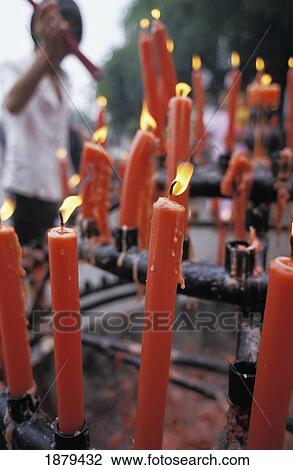 Stock Image - Man Lighting Incense Candles At Big Wild Goose Pagoda. Fotosearch