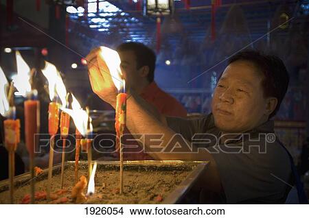 Man Lighting Up Candle In Temple View Large Photo Image Picture - Man Lighting Up Candle In Temple. Fotosearch
