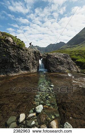 Man looking at small waterfall near the Fairy Pools in Coire na Creiche, Black Cuillin; Isle of Skye, Scotland View Large Photo Image Stock Image - Man looking at small waterfall near the Fairy Pools in Coire na Creiche, Black Cuillin; Isle of Skye, Scotland. Fotosearch