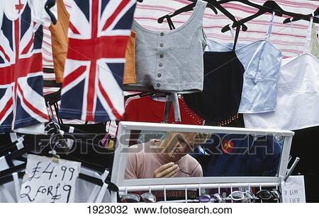 Stock Image - Man Looking At Sunglasses At A Stall. Fotosearch