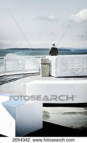 Stock Image - Man Looking At The Water From A Ferry's Stern, Swartz Bay, Bc. Fotosearch