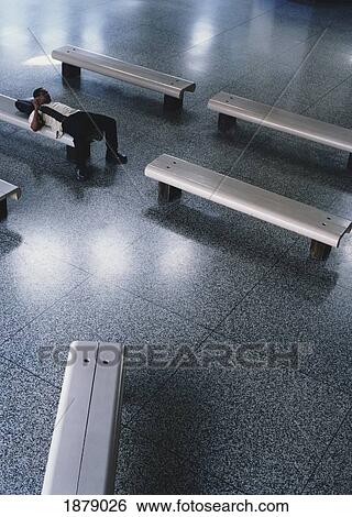 Stock Photograph - Man Lying On Bench In Airport. Fotosearch