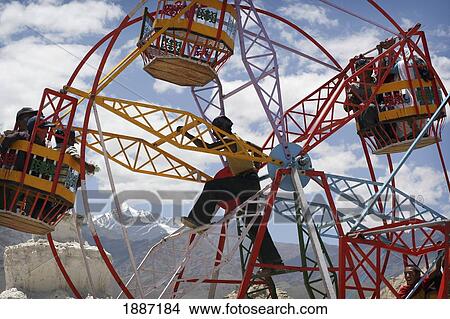 Man Manually Operating Small Ferris Wheel At A Fun Fair In Leh. View Large Photo Image Picture - Man Manually Operating Small Ferris Wheel At A Fun Fair In Leh.. Fotosearch