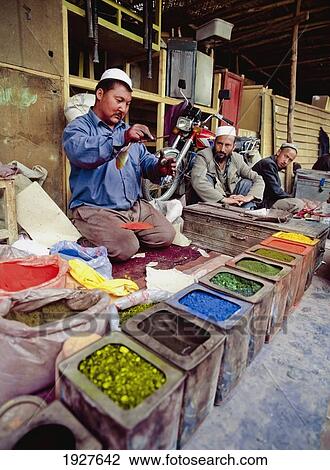Stock Image - Man Measuring Out Clothes Dyes. Fotosearch