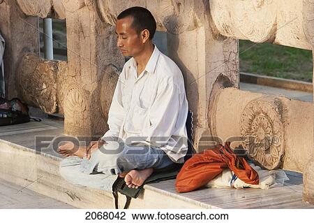 Stock Image - Man Meditating, Mahabodi Temple, Bodhgaya, Bihar, India. Fotosearch