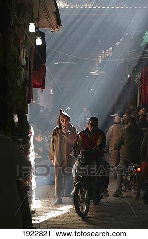 Stock Image - Man On Motorcycle Through Souk, Marrakesh, Morocco. Fotosearch