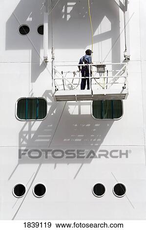 Man On Platform Painting Ship; Philipsburg City, St. Maarten Island, Netherlands Antilles, Caribbean View Large Photo Image Stock Photo - Man On Platform Painting Ship; Philipsburg City, St. Maarten Island, Netherlands Antilles, Caribbean. Fotosearch