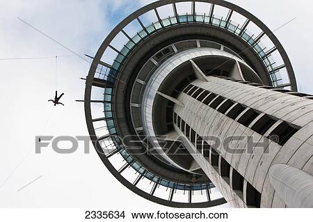 Picture - Man On Rope Jumping From Modern Tower; New Zealand. Fotosearch