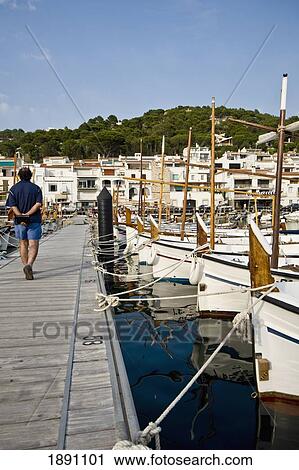 Man Passing Boats In Fishermen Village Port De La Selva View Large Photo Image Stock Image - Man Passing Boats In Fishermen Village Port De La Selva. Fotosearch