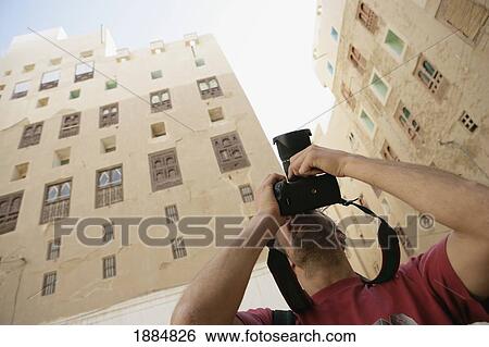 Man Photographing Mud Skyscrapers View Large Photo Image Stock Photograph - Man Photographing Mud Skyscrapers. Fotosearch