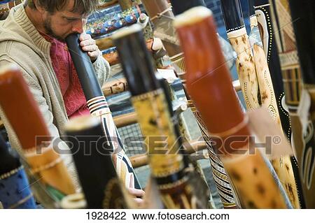 Stock Image - Man Playing Didgeridoo At Stall In Market, Sydney, New South Wales, Australia. Fotosearch