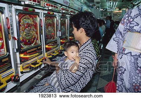 Stock Image - Man Playing Pachinko With Baby. Fotosearch