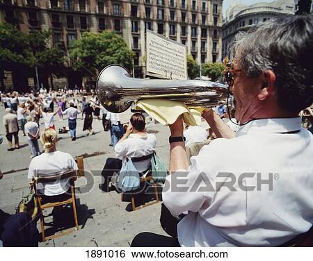 Stock Photograph - Man Playing Trumpet In Front Of Barcelona Cathedral. Fotosearch