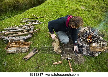 Stock Photo - Man Preparing Camp Fire In Field, Dartmoor National Park, Postbridge, Yelverton, Devon, Uk. Fotosearch