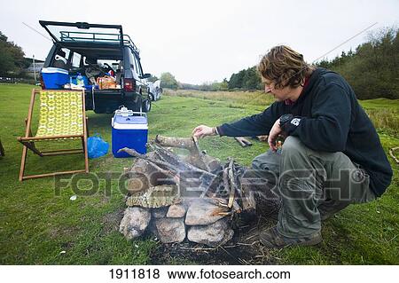 Stock Photo - Man Preparing Camp Fire In Field, Dartmoor National Park, Postbridge, Yelverton, Devon, Uk. Fotosearch
