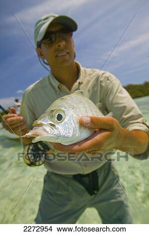 Picture - Man Proudly Showing Off A Freshly Caught Fish; Bahamas. Fotosearch