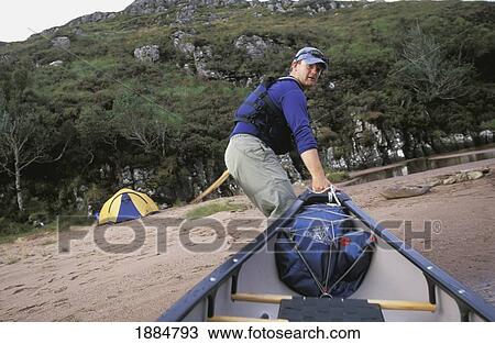 Man Pulling Canoe Ashore Rear Campsite View Large Photo Image Stock Image - Man Pulling Canoe Ashore Rear Campsite. Fotosearch