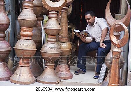 Man Reading In The Copper Souk At Khan Al-Khalili Bazaar, Cairo, Al Qahirah, Egypt View Large Photo Image Picture - Man Reading In The Copper Souk At Khan Al-Khalili Bazaar, Cairo, Al Qahirah, Egypt. Fotosearch
