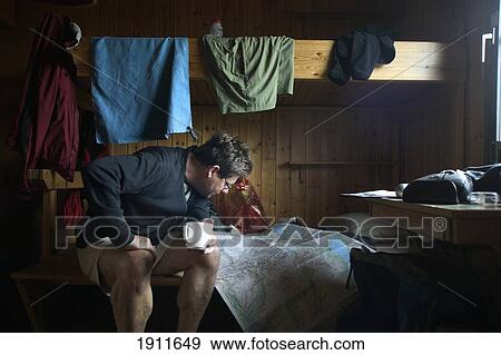 Stock Photo - Man Reading Map Inside Hikers' Cabin, Kungsleden Trail, Abisko, Sweden. Fotosearch