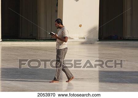 Stock Image - Man Reading The Koran In The Al-Hakim Mosque, Cairo, Al Qahirah, Egypt. Fotosearch