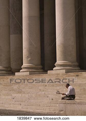 Stock Photo - Man Readning Newspaper, Stairs With Columns In Background; Naples, Italy. Fotosearch