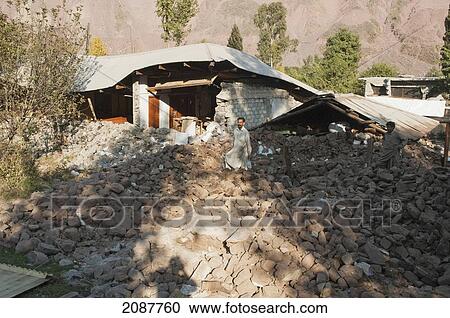 Stock Image - Man Removing The Rubble Of His Home, Destroyed By The 8 October 2005 Earthquake, Tandali, Azad Kashmir, Pakistan. Fotosearch