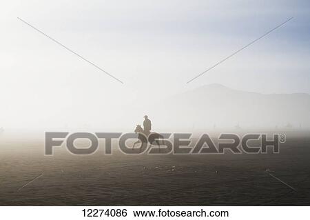 Man riding a horse in the Tengger Sand Sea, Bromo Tengger Semeru National Park, East Java, Indonesia View Large Photo Image Stock Photograph - Man riding a horse in the Tengger Sand Sea, Bromo Tengger Semeru National Park, East Java, Indonesia. Fotosearch