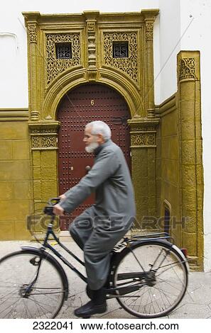 Man riding his bike and passing ornate entry to building in Quartier Habbous; Casablanca, Morocco View Large Photo Image Stock Image - Man riding his bike and passing ornate entry to building in Quartier Habbous; Casablanca, Morocco. Fotosearch