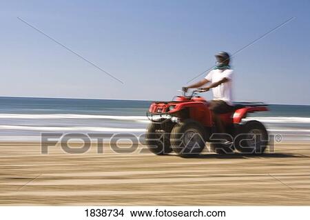 Picture - Man Riding Quad On Sandy Beach; Mazatlan, Sinaloa State, Mexico. Fotosearch