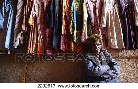 Man sat selling clothes Jaisalmer Rajasthan India View Large Photo Image Stock Photo - Man sat selling clothes Jaisalmer Rajasthan India. Fotosearch