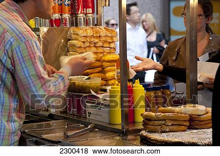 Stock Photo - Man Selling Hot Dogs In Midtown Manhattan, New York, Usa. Fotosearch