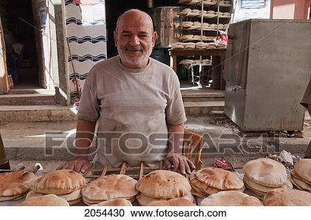 Stock Image - Man Selling Pita Bread At A Bakery, Rosetta (Rashid), Beheira, Egypt. Fotosearch