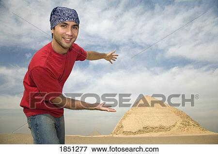 Stock Photo - Man Showing Off Pyramid In Background. Fotosearch