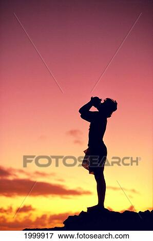 Stock Photo - Man Silhouetted At Sunset, Conch Shell Blower. Fotosearch