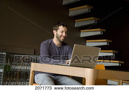 Man Sitting At A Laptop, Toronto, Ontario View Large Photo Image Stock Image - Man Sitting At A Laptop, Toronto, Ontario. Fotosearch