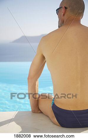 Man Sitting By Swimming Pool By Sea View Large Photo Image Stock Photo - Man Sitting By Swimming Pool By Sea. Fotosearch