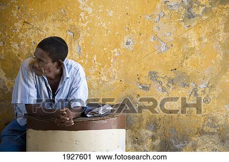 Stock Image - Man Sitting By Wall. Fotosearch