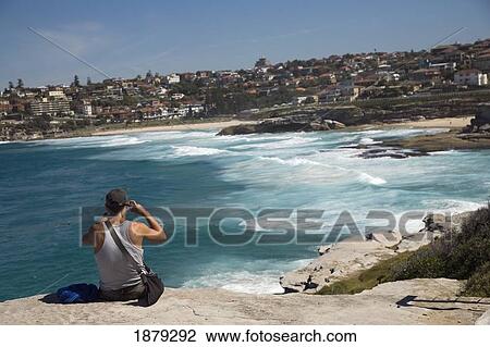 Man Sitting On Rock Over Looking Mackensies And Tamarama Bay, Near Bondi Beach View Large Photo Image Stock Image - Man Sitting On Rock Over Looking Mackensies And Tamarama Bay, Near Bondi Beach. Fotosearch
