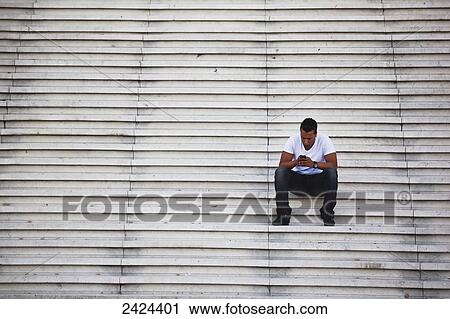 Man sitting on steps using his smart phone; Paris, France View Large Photo Image Stock Image - Man sitting on steps using his smart phone; Paris, France. Fotosearch