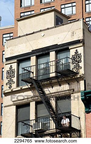 Stock Photography - Man Sitting Outside A Traditional Apartments Building In Tribeca, Manhattan, New York, Usa. Fotosearch