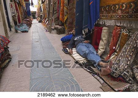 Man Sleeping On A Carpet Outside His Shop In The Carpet Market In Essaouira, Morocco View Large Photo Image Stock Image - Man Sleeping On A Carpet Outside His Shop In The Carpet Market In Essaouira, Morocco. Fotosearch