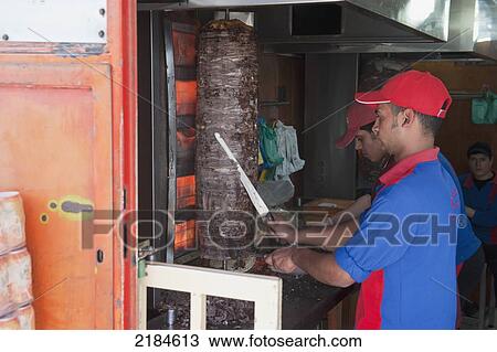 Stock Image - Man Slicing Meat At Reem Shawarma Stand, Amman, Jordan, Middle East. Fotosearch