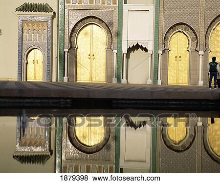 Stock Photo - Man Standing By Pool, Reflection Of Building In Water, Dar El-Makhzen. Fotosearch