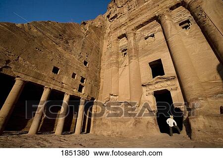 Stock Image - Man Standing By Royal Tomb In Petra. Fotosearch