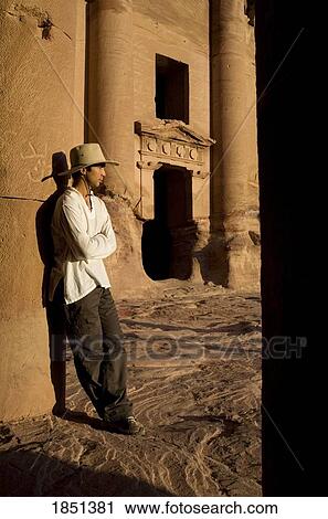 Stock Image - Man Standing By Royal Tomb In Petra. Fotosearch