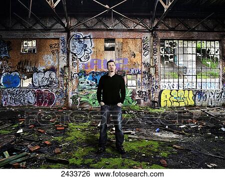 Man standing in abandoned industrial building covered in graffiti; Montreal, Quebec, Canada View Large Photo Image Stock Photograph - Man standing in abandoned industrial building covered in graffiti; Montreal, Quebec, Canada. Fotosearch