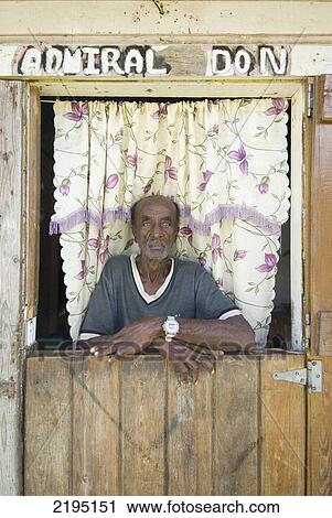 Man Standing In The Doorway Of His House Near La Sagesse On The East Coast Of Grenada. View Large Photo Image Stock Image - Man Standing In The Doorway Of His House Near La Sagesse On The East Coast Of Grenada.. Fotosearch