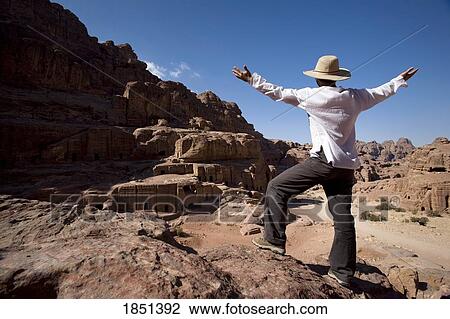 Stock Image - Man Standing Near Monumental Nabataean Tombs. Fotosearch