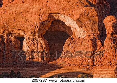 Man Standing Under Large Cliff At The Cove Of Caves In Arches National Park, Utah. View Large Photo Image Stock Photo - Man Standing Under Large Cliff At The Cove Of Caves In Arches National Park, Utah.. Fotosearch