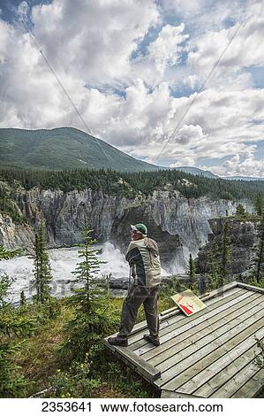 Man Stands At The Lookout Above Virginia Falls In Nahanni National Park Reserve; Northwest Territories, Canada View Large Photo Image Stock Image - Man Stands At The Lookout Above Virginia Falls In Nahanni National Park Reserve; Northwest Territories, Canada. Fotosearch